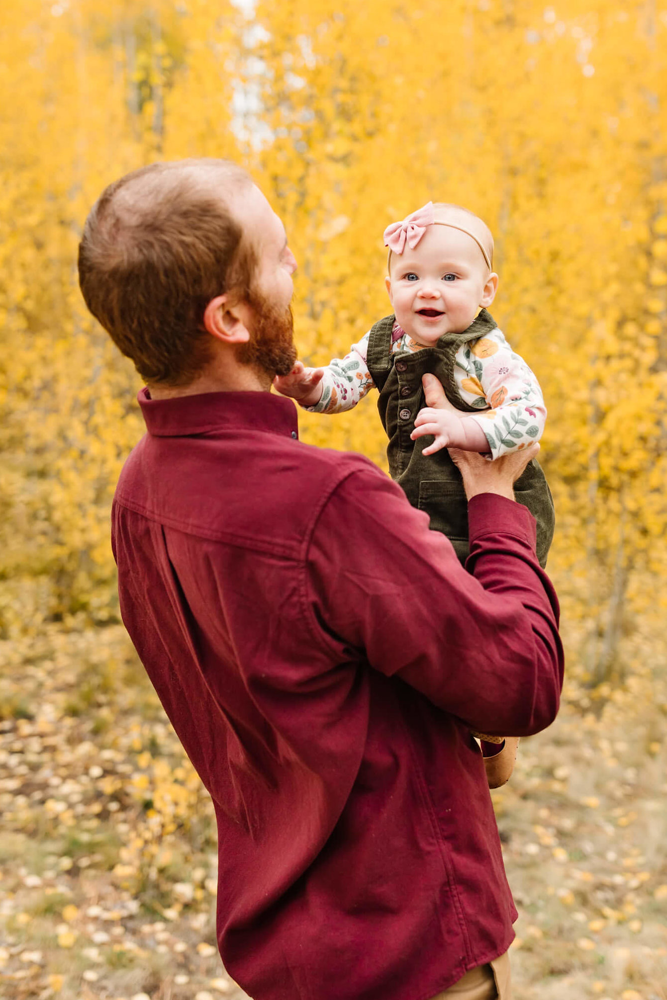 father in maroon holding baby in bend oregon shevlin park