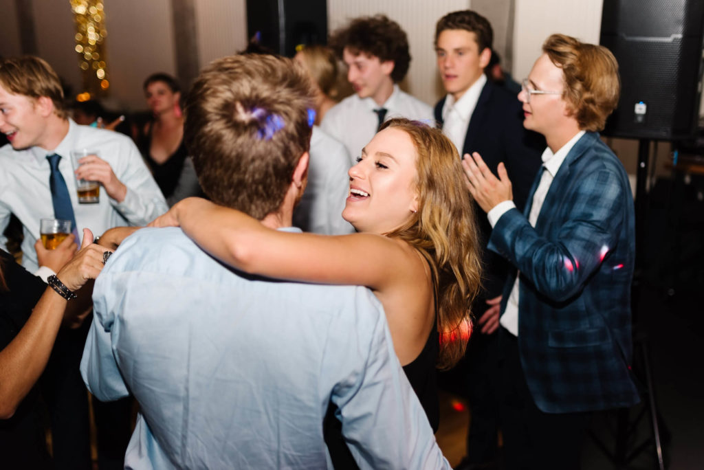 blonde girl with her arms around a guy dancing