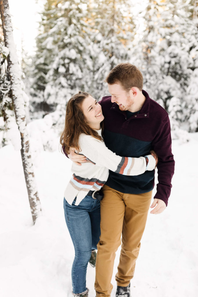 girl and guy hugging and walking in snow