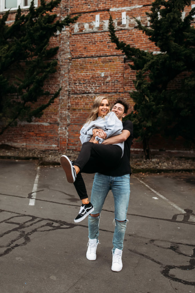 playful-couples-poses-downtown-couple-swinging-partner-from-behind