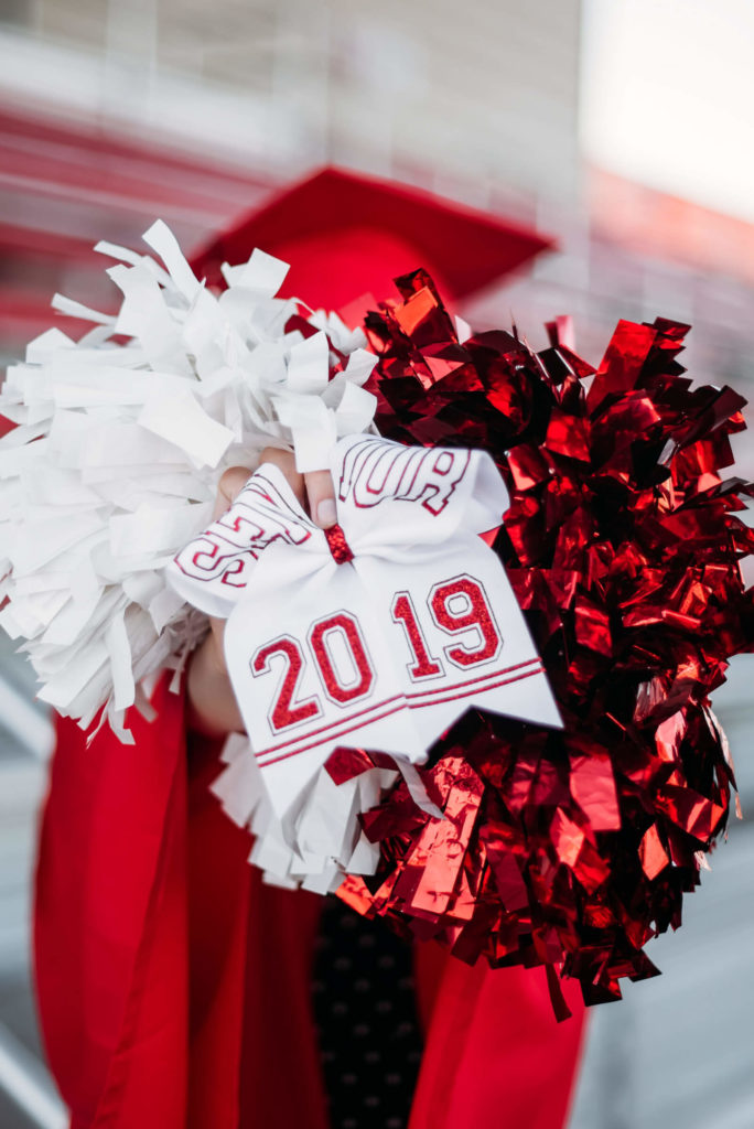 red and white cheer pom poms with a bow reading 2019