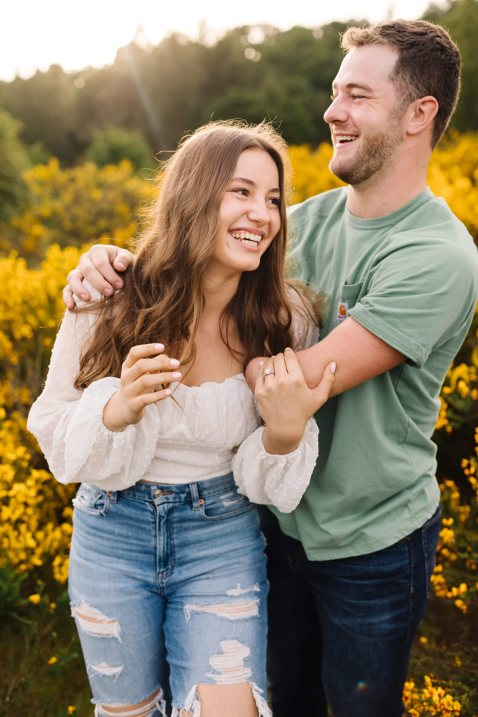 girl in white top being hugged by man in green shirt photographed by bend wedding photographers