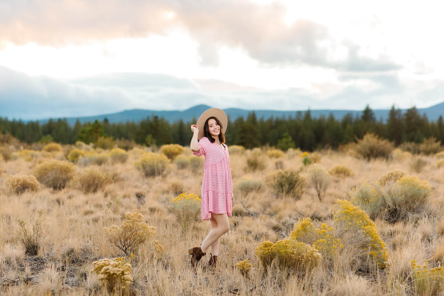 girl in pink dress standing in open field in bend oregon