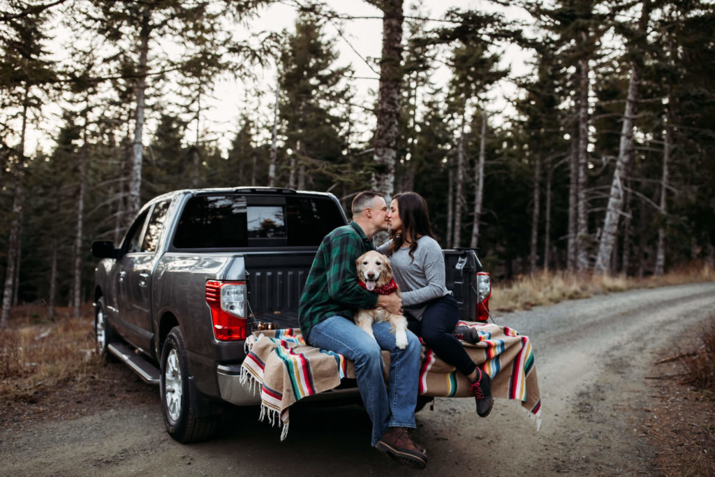 a couple kissing in the back of a pickup truck during a romantic couples photoshoot