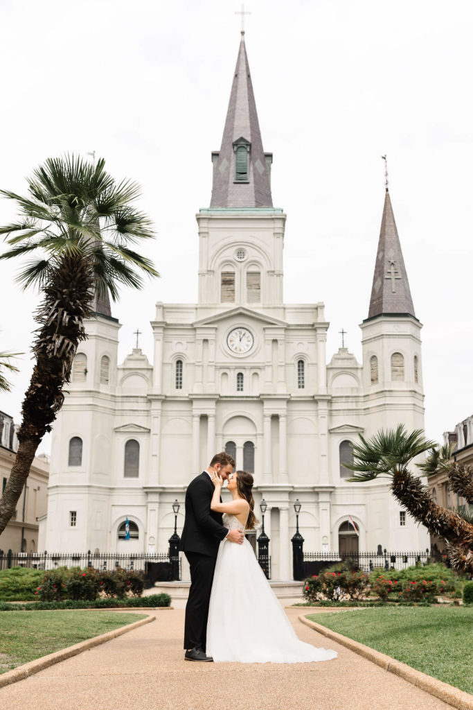 bride and groom kissing in jackson square in wedding day wear