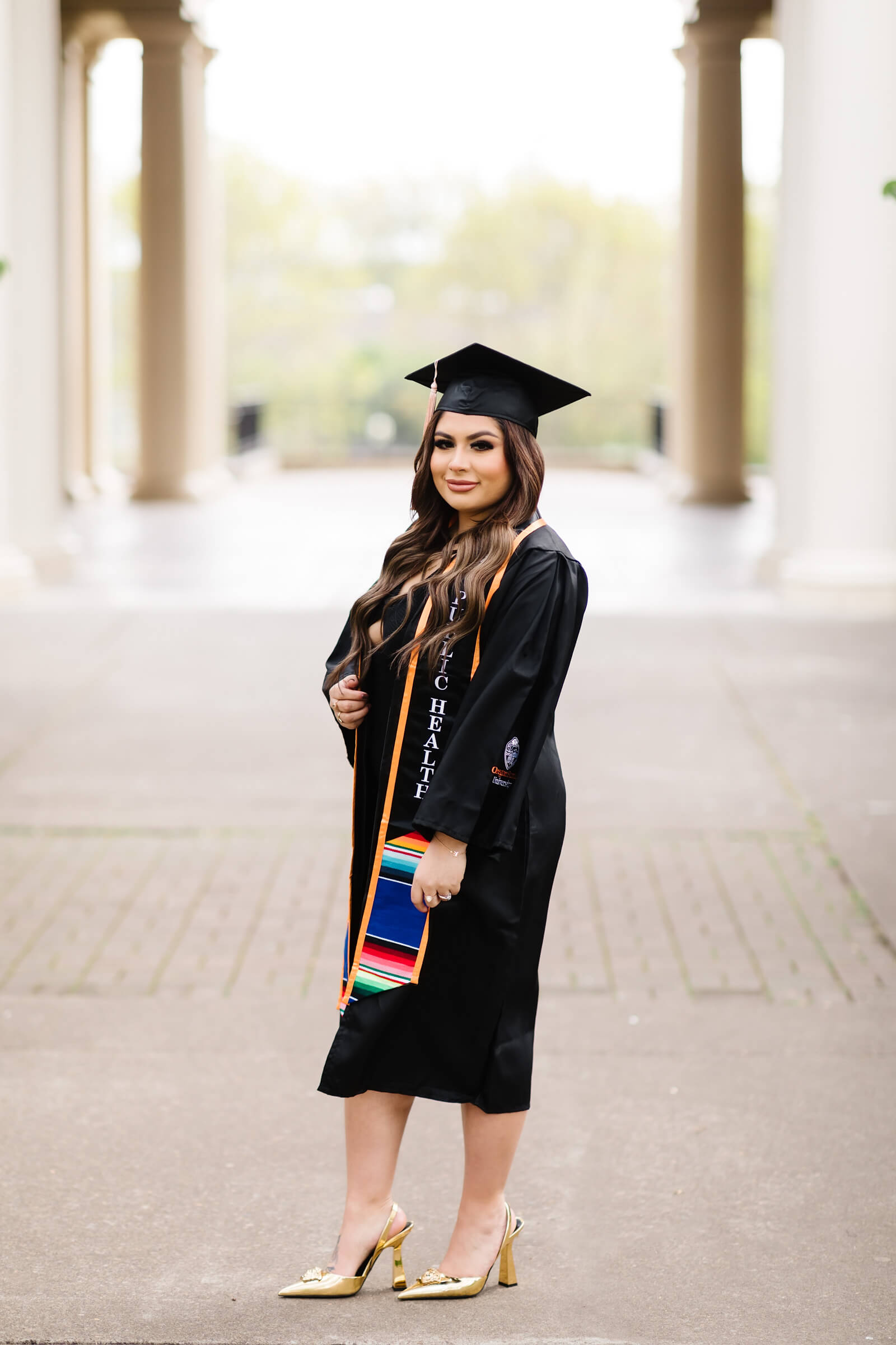 girl in Oregon State Graduation cap and gown in front of Weatherford Hall