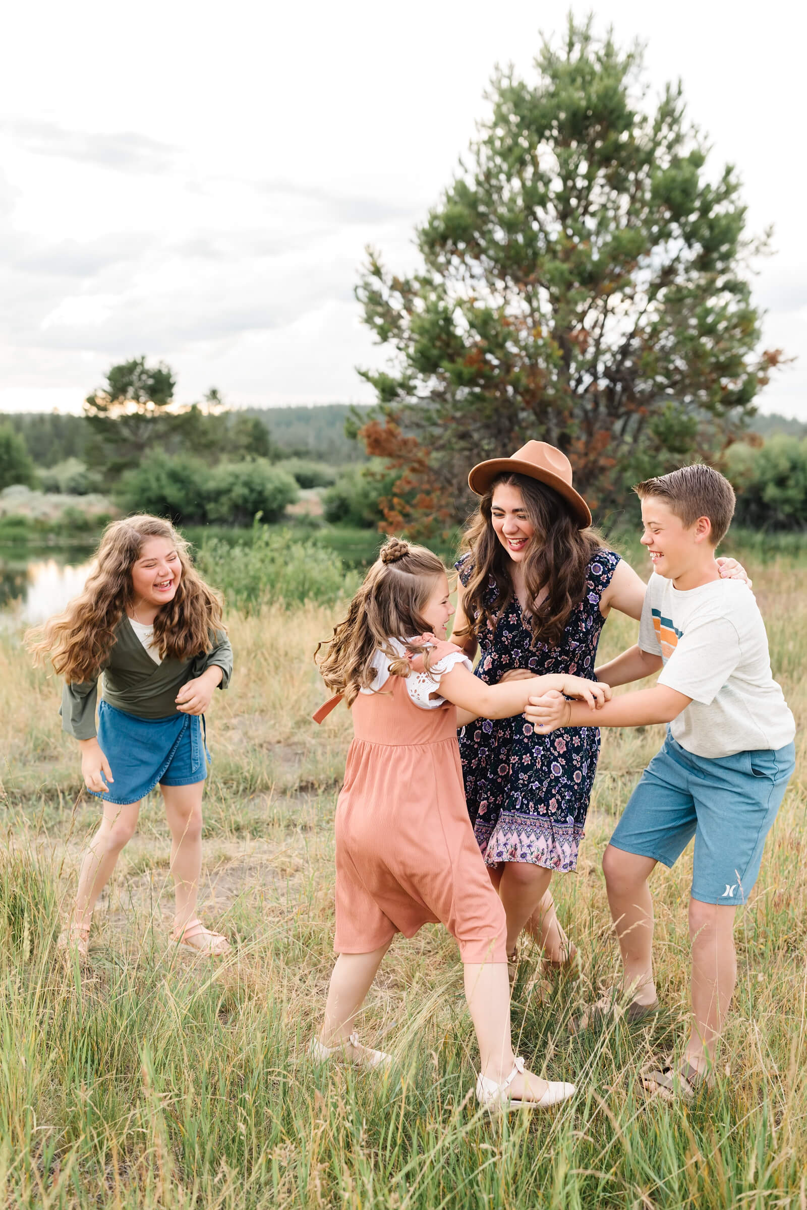 4 siblings playing tag during extended family photoshoot