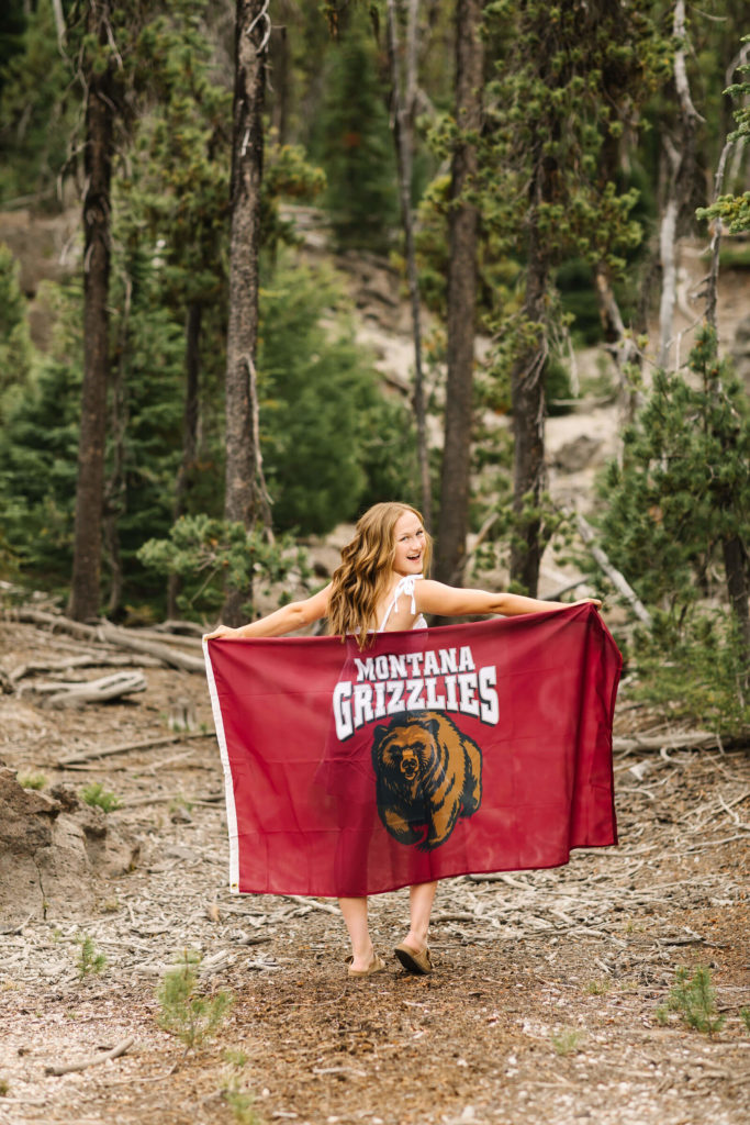 blonde girl holding montana grizzlies flag at sparks lake
