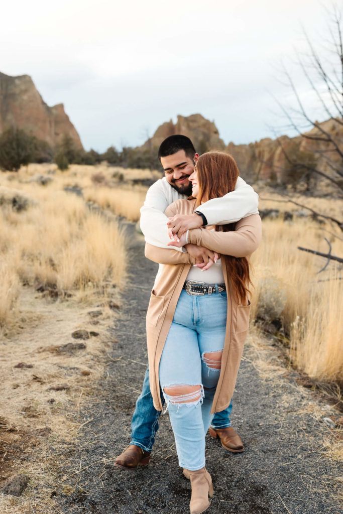 male hugging woman with red hair from behind at smith rock family photoshoot