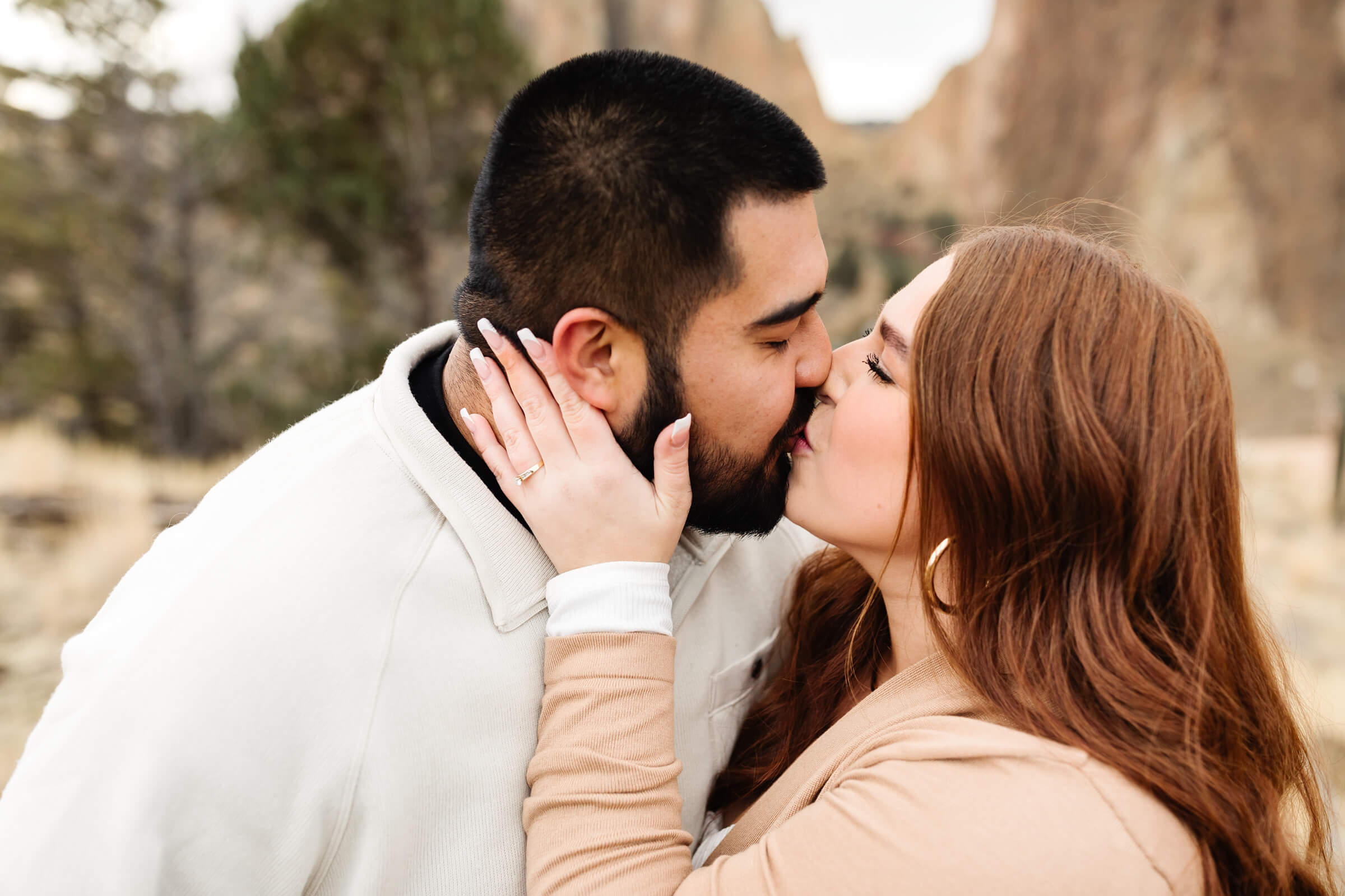 newly engaged couple kissing during smith rock family photoshoot