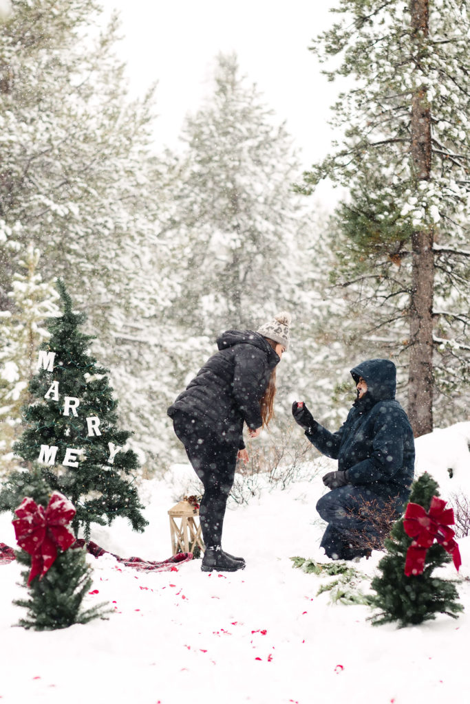 man kneeling on one knee in snow at mt. bachelor during winter proposal at christmas