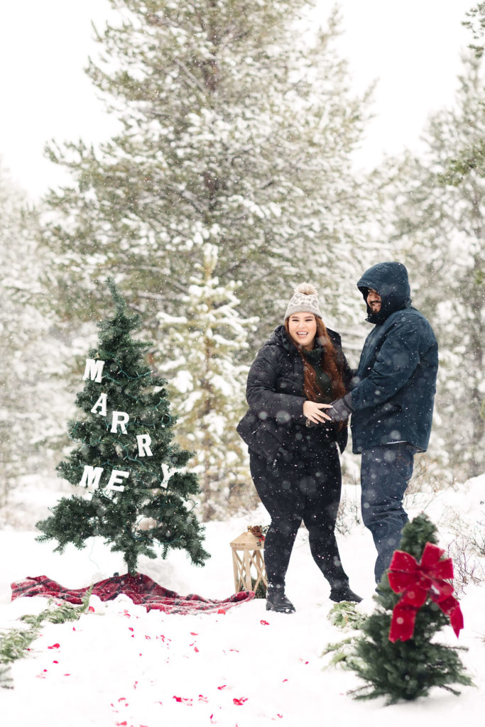 woman with red hair surprised by family after snowy winter proposal