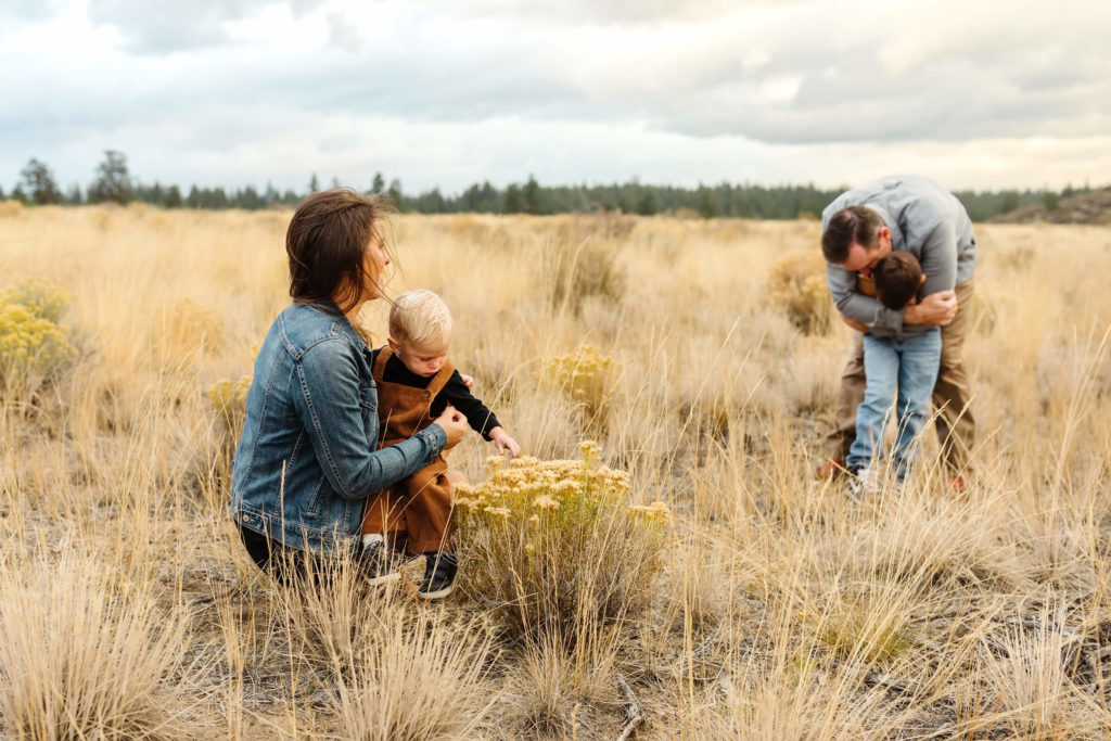 family of four dressed in navy and buckskin colors at Shevlin Park during fall family photosession
