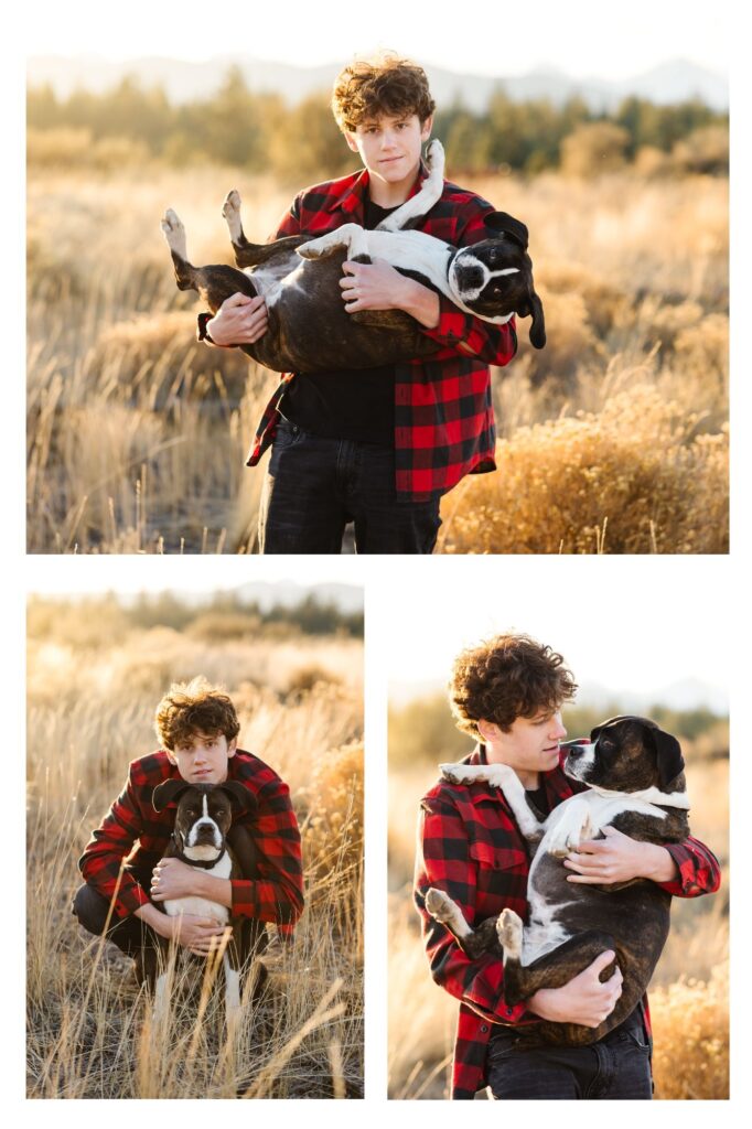 young teen with curly brown hair and wearing red flannel holding his boxer dog in open field during golden hour of his Senior Photoshoot